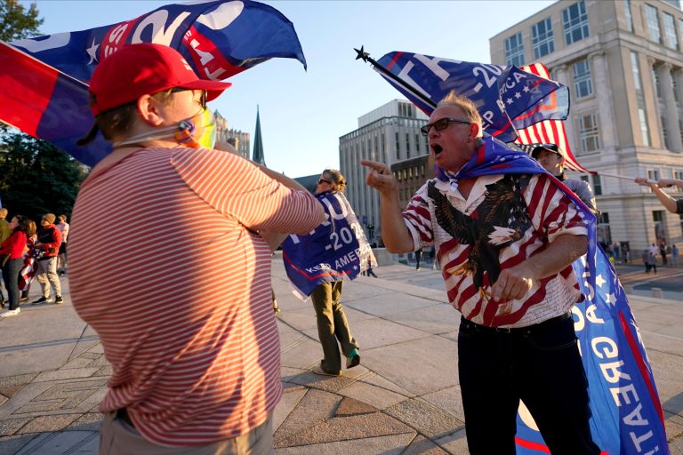 A supporter of  Joe Biden, left, exchanges viewpoints with supporters of President Donald Trump, right, outside the Pennsylvania State Capitol, Saturday, Nov. 7, 2020, in Harrisburg, Pa.