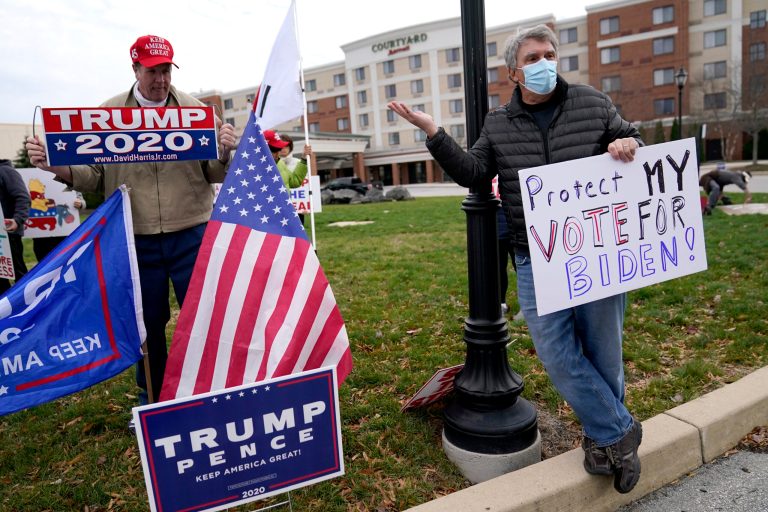 Unity? Not so fast. A supporter of President  Trump, left, and a supporter of Joe Biden argue outside of the Wyndham Hotel where the Pennsylvania State Senate Majority Policy Committee is scheduled to meet, Wednesday, Nov. 25, 2020, in Gettysburg, Pa.