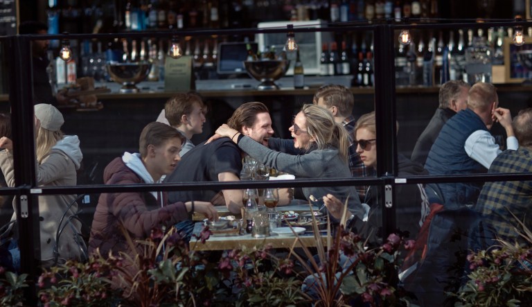 In this Saturday, April 4, 2020 file photo a couple hug and laugh as they have lunch in a restaurant in Stockholm, Sweden.                                                                                                                                                   