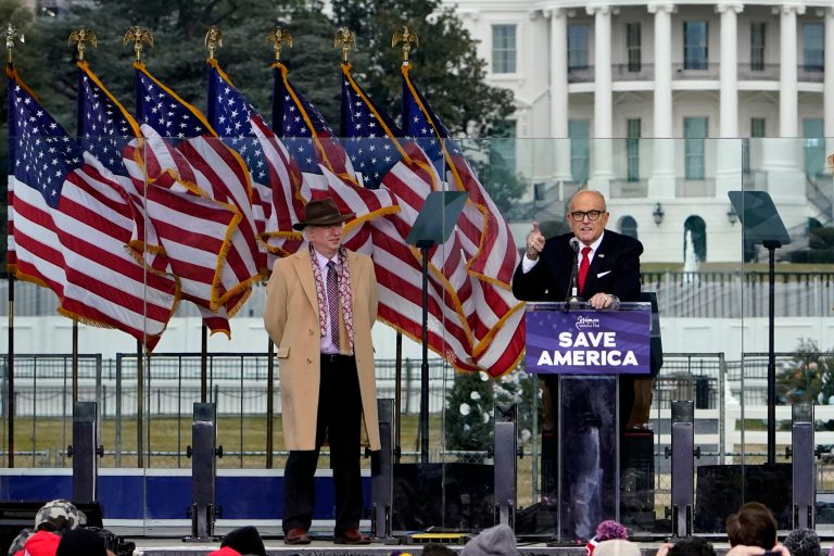 John Eastman stands at left as former New York Mayor Rudolph Giuliani speaks in Washington at a rally in support of President Donald Trump.