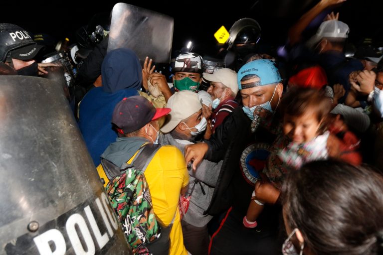 Honduran security forces try to keep migrants who are trying to reach the U.S. from crossing the border in El Florido, Honduras into Guatemala, Friday, Jan. 15, 2021.