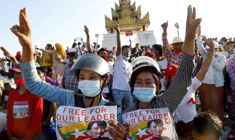 Demonstrators display placards calling for the release of detained Myanmar leader Aung San Suu Kyi and flash three-fingered salutes, a symbol of resistance, against the military coup during a protest in Mandalay, Myanmar, Wednesday, Feb. 10, 2021.