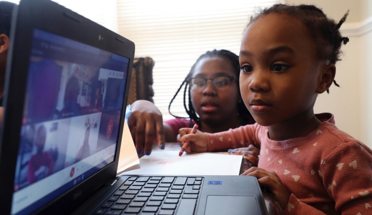 4-year-old Lear Preston of Scott Joplin Elementary School attends her online classes as her mother Brittany Preston assists her from the side in their residence in South Side, Chicago on Wednesday, Feb. 10, 2021. Starting Thursday, Lear will return to class as the nationâs third-largest school district slowly reopens its doors following a bitter fight with the teachers union over COVID-19 safety protocols.