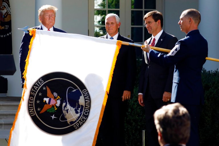 President Donald Trump, left, watches with Vice President Mike Pence and Defense Secretary Mark Esper as the flag for U.S. Space Command is unfurled.