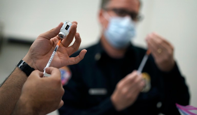 Health workers prepare doses of a COVID-19 vaccine at the Martin Luther King Senior Center, in North Las Vegas. 
