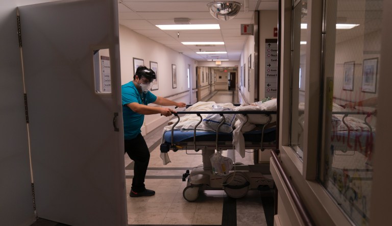 In this Friday, Feb. 19, 2021, file photo, medical transporter Adrian Parrilla moves a patient into a COVID-19 unit at Mission Hospital in Mission Viejo, Calif. There are 3,250 people hospitalized statewide, a drop of more than 85% since peaking around 22,000 in early January, the state Department of Public Health reported Saturday, March 13, 2021.