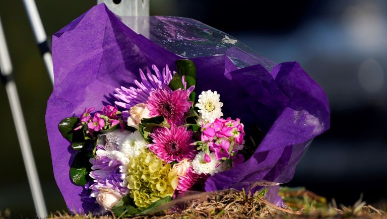 A small memorial stands next to a sign across the street from the King Soopers grocery store where a mass shooting took place Tuesday, March 23, 2021, in Boulder, Colo.
