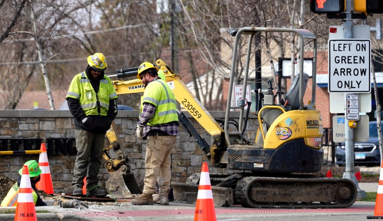 Construction workers work in Wheeling, Ill. President Joe Biden's infrastructure plan aims to revitalize U.S. transportation infrastructure, water systems, broadband and manufacturing.