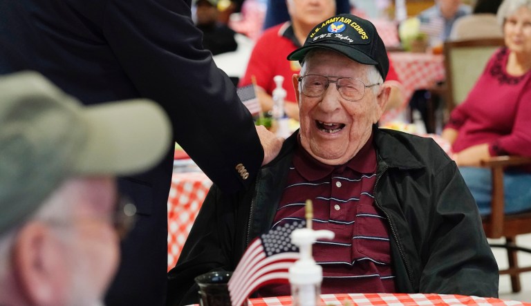 Howard Bennett, a U.S. Army Air Corps veteran, laughs as he speaks with his son, Steve Bennett, left, visiting for the first time without the use of protective garments at the Mississippi State Veterans Home in Collins, Miss., Thursday, April 1, 2021.