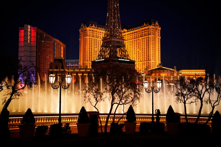 In this Nov. 19, 2020, file photo, a woman watches the fountains at the Bellagio hotel-casino along the Las Vegas Strip in Las Vegas.