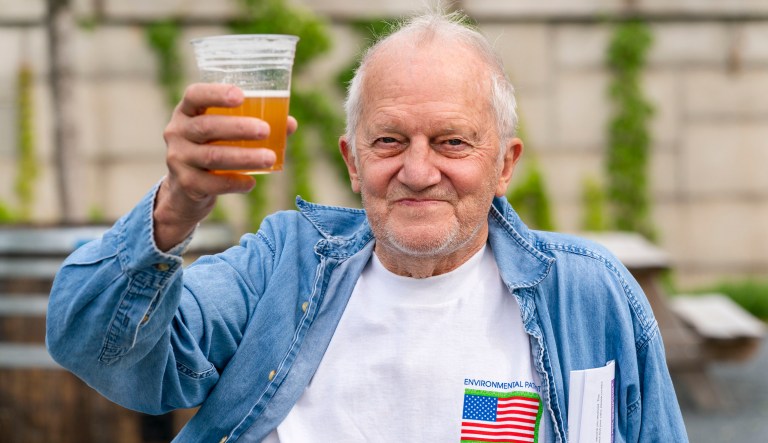In this May 6, 2021 photo, George Ripley, 72, of Washington, holds up his free beer after receiving the J & J COVID-19 vaccine shot, at The REACH at the Kennedy Center in Washington.