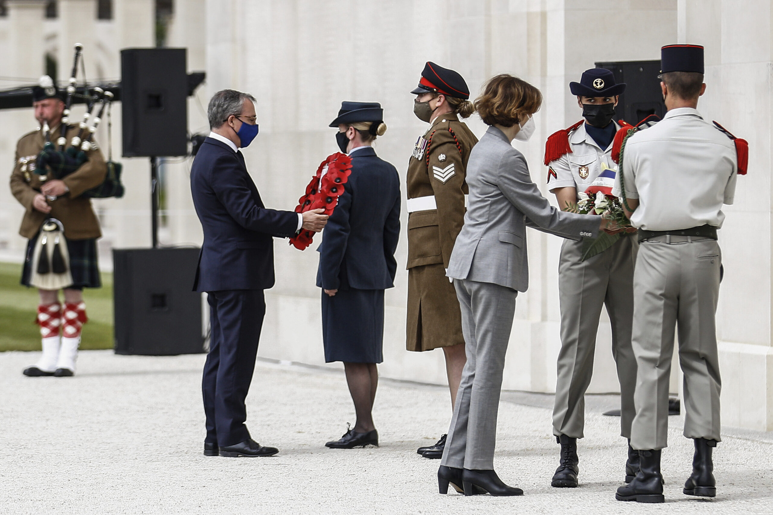 British ambassador to France, Edward Llewellyn, left, and French Defense Minister Florence Parly lay wreaths of flowers