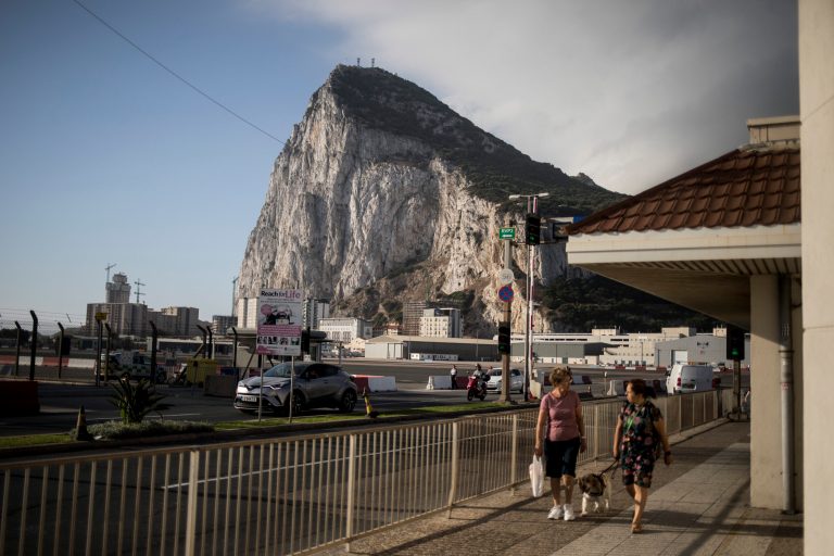 Backdropped by the Gibraltar rock, people cross the Gibraltar airport runway, Thursday, June 24, 2021. Gibraltar was recently recognized as a British city after being omitted for 180 years.