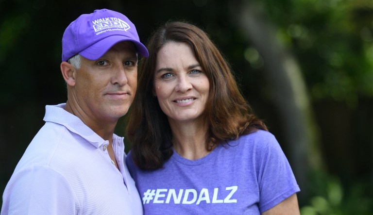 Michele Hall stands with her husband, Doug, in their backyard Thursday, June 24, 2021, in Bradenton, Fla. Hall, 53, diagnosed with early Alzheimerâs last year, calls the new drug Aduhelm âthe first tiny glimmer of hopeâ sheâll get more quality time with her husband and their three adult children.