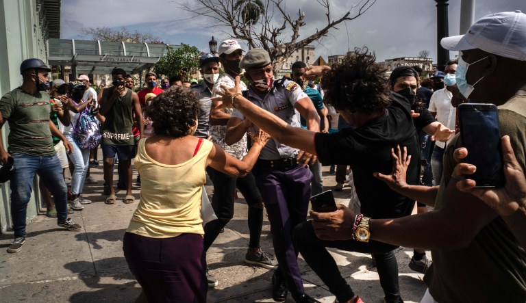 Police scuffle and detain an anti-government demonstrator during a protest in Havana, Cuba, Sunday July 11, 2021. Hundreds of demonstrators went out to the streets in several cities in Cuba to protest against ongoing food shortages and high prices of foodstuffs, amid the new coronavirus crisis. 