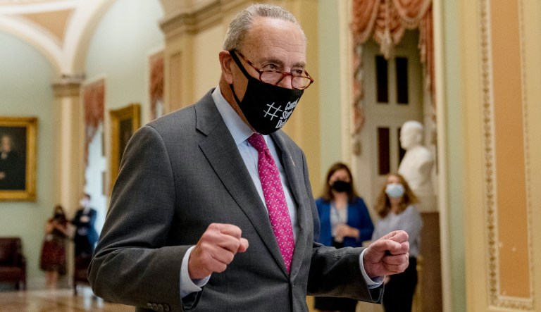 Senate Majority Leader Chuck Schumer of N.Y. walks off the Senate floor and pumps his fists as the Senate approves a $1 trillion bipa cornerstone of the Biden agenda to the House, on Capitol Hill in Washington, Tuesday, Aug. 10, 2021.