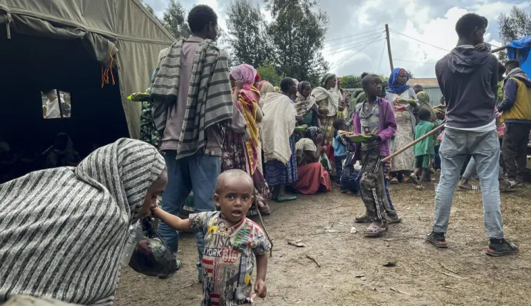Displaced Amharas from different villages, now controlled by Tigrayan forces in the North Gondar zone, queue to receive food at a kindergarten school housing the internally-displaced.