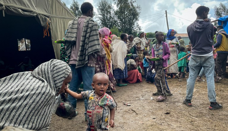 Displaced Amharas from different villages now controlled by Tigrayan forces in the North Gondar zone, queue to receive food at a kindergarten school housing the internally-displaced, in Debark, in the Amhara region of northern Ethiopia Wednesday, Aug. 25, 2021.
