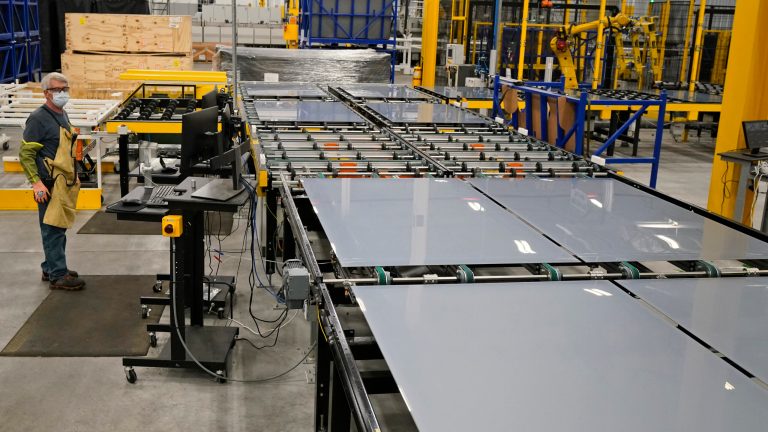 Machine operator Chuck Smith watches as solar panels are manufactured on the assembly line at the First Solar manufacturing plant Wednesday, Oct. 6, 2021, in Walbridge, Ohio. First Solar is a leading global provider of comprehensive PV solar systems using advanced module and system technology. 
