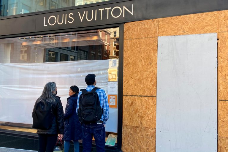 FILE - Union Square visitors look at damage to the Louis Vuitton store on Nov. 21, 2021, after looters ransacked businesses in San Francisco. (Danielle Echeverria/San Francisco Chronicle via AP, File)