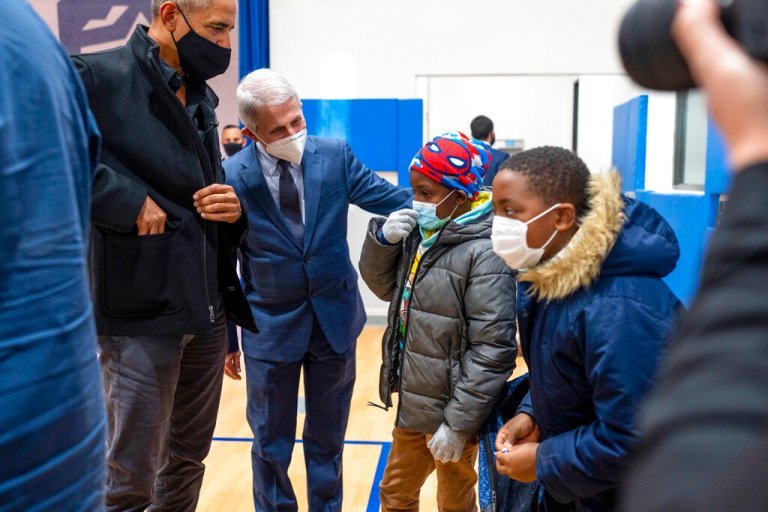 Former President Barack Obama and Dr. Anthony Fauci, director of the National Institute of Allergy and Infectious Diseases, talk with elementary school students as they prepare to get their second vaccine shots at the Kimball Elementary School in Washington, on Tuesday, Nov. 30, 2021.