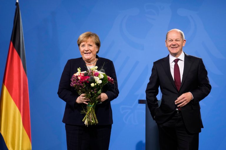 New elected German Chancellor Olaf Scholz, right, and former Chancellor Angela Merkel laugh together during a handover ceremony in the chancellery in Berlin, Wednesday, Dec. 8, 2021.