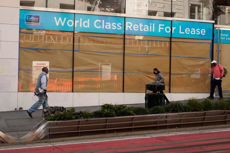 People walk past a large retail space for lease at Union Square in San Francisco, Thursday, Dec. 2, 2021.