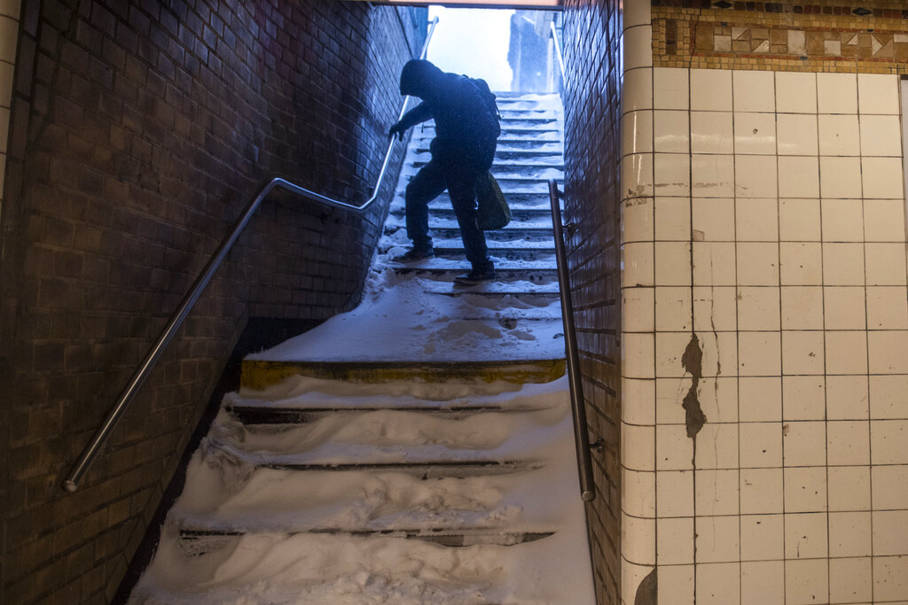A man carefully walks down the snow-covered subway stairs during a snow storm in the Bushwick section of the Brooklyn borough of New York on Saturday.