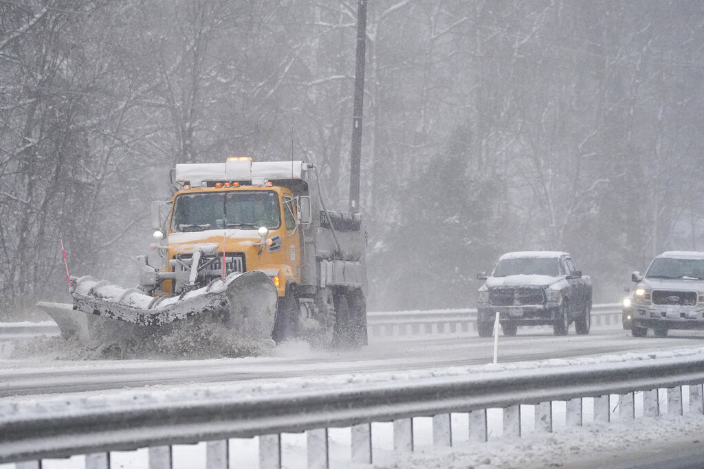 Vehicles follow a snowplow on Highway 50 during a snowstorm Saturday in Mardela Springs, Maryland. 