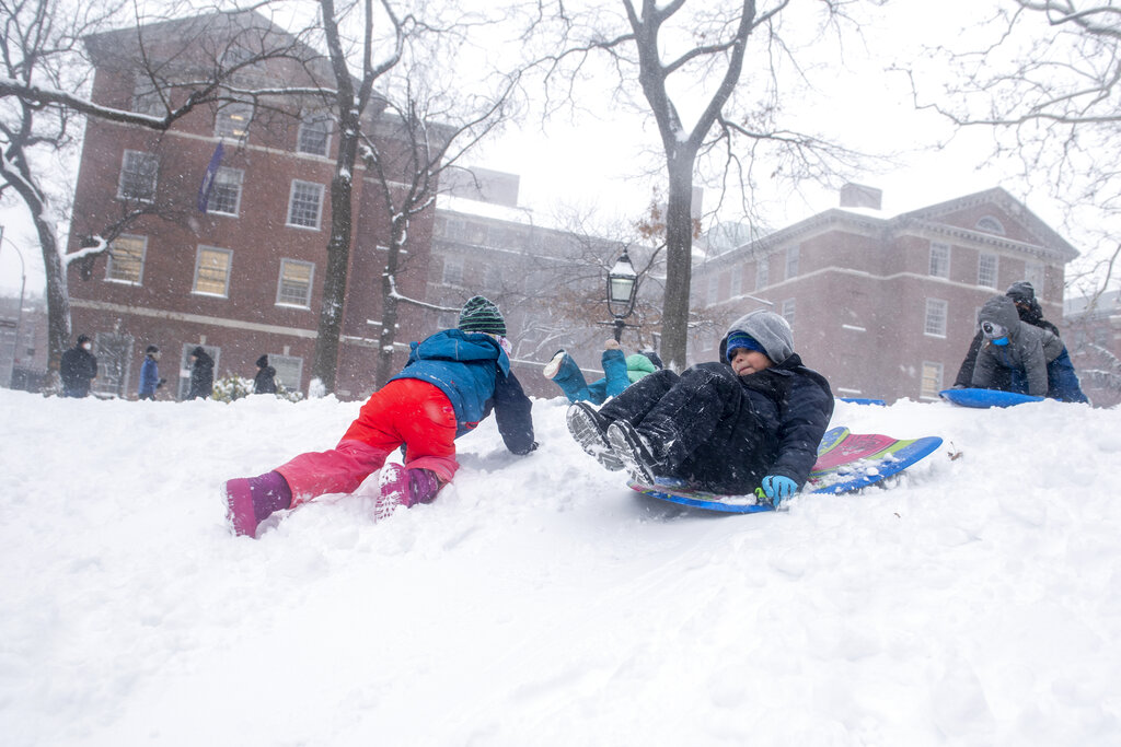 Children play during a snow storm in Washington Square Park on Saturday in New York.