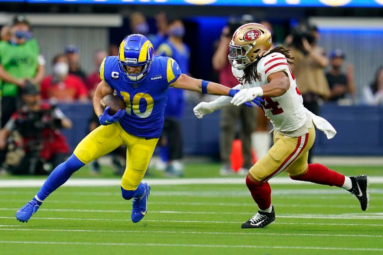 Los Angeles Rams's Cooper Kupp, left, is stopped by San Francisco 49ers's Fred Warner during the first half of the NFC Championship NFL football game Sunday, in Inglewood, California.