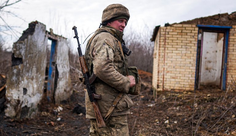 A Ukrainian serviceman stands at his position at the line of separation between Ukraine-held territory and rebel-held territory near Svitlodarsk, eastern Ukraine, Wednesday, Feb. 23, 2022. U.S. President Joe Biden announced the U.S. was ordering heavy financial sanctions against Russia, declaring that Moscow had flagrantly violated international law in what he called the 