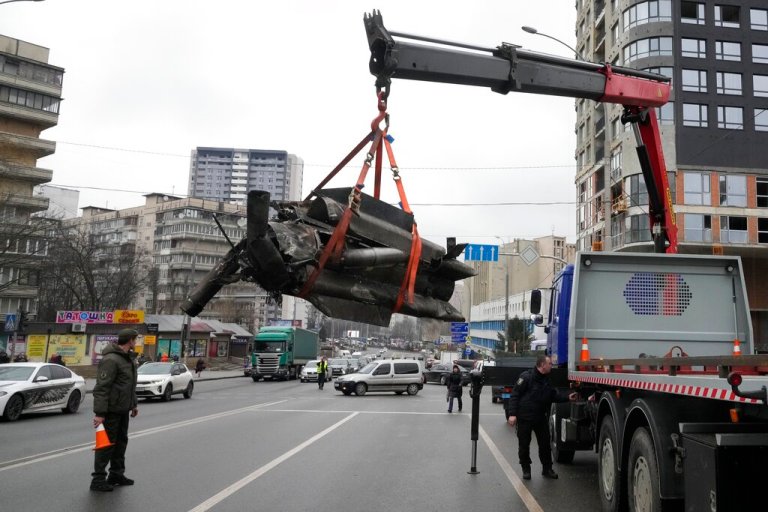Workers load the debris of a rocket onto a truck in the aftermath of an apparent Russian strike in Kyiv, Ukraine, Thursday.
