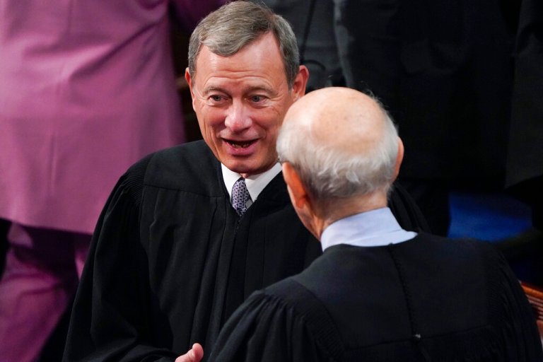 Chief Justice of the United States John Roberts talks with retiring Supreme Court Associate Justice Stephen Breyer before President Joe Biden delivers his first State of the Union address to a joint session of Congress, at the Capitol in Washington, Tuesday, March 1, 2022. 