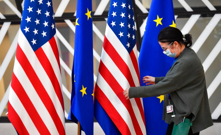 A member of protocol adjusts the U.S. and EU flags prior to the arrival of ministers for an extraordinary EU foreign ministers meeting at the European Council building in Brussels, Friday, March 4, 2022. U.S. Secretary of State Antony Blinken meets Friday with his counterparts from NATO and the European Union, as Russia's war on Ukraine entered its ninth day marked by the seizure of the strategic port city of Kherson and the shelling of Europe's largest nuclear power plant. 