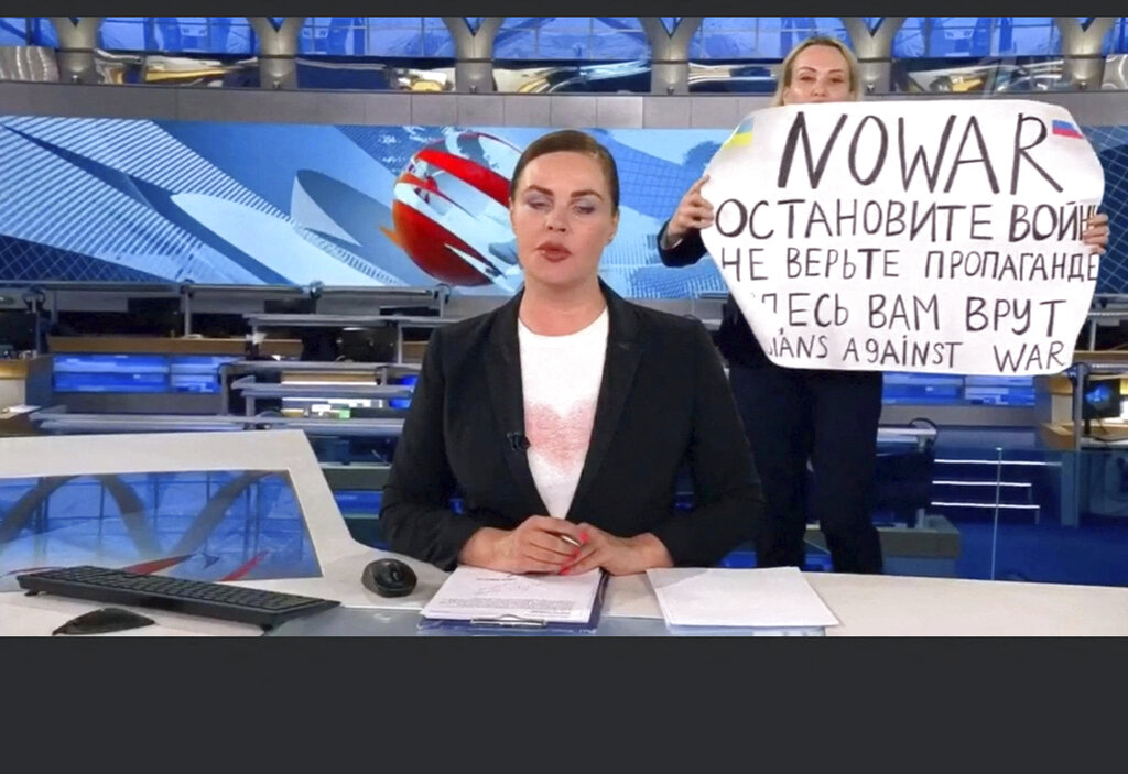 This video grab taken on Tuesday shows Russian Channel One editor Marina Ovsyannikova holding a poster reading, "Stop the war. Don't believe the propaganda. Here they are lying to you," during an on-air TV broadcast by news anchor Yekaterina Andreyeva, Russia's most-watched evening news broadcast, in Moscow on Monday. 