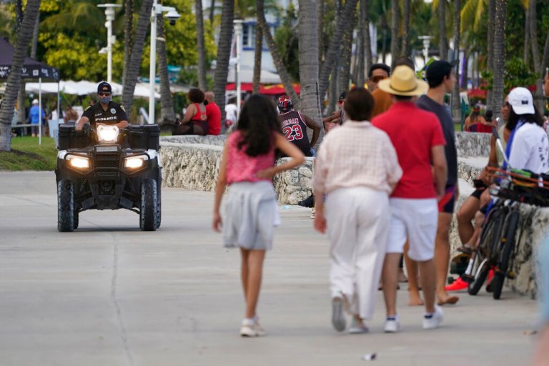 FILE - A police officer on an ATV patrols in Miami Beach, Florida's famed South Beach, Monday, March 22, 2021. (AP Photo/Wilfredo Lee, File)