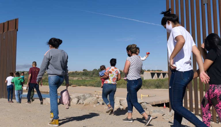 This Tuesday, June 8, 2021, photo shows a group of Brazilian migrants making its way around a gap in the U.S.-Mexico border in Yuma, Arizona, seeking asylum in the United States after crossing over from Mexico. 