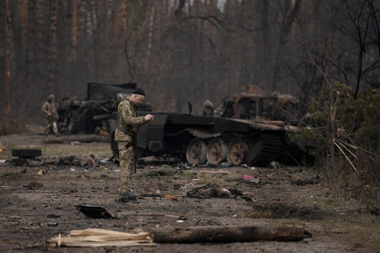 A Ukrainian serviceman takes a photo of a dead Russian soldier after Ukrainian forces overran a Russian position outside Kyiv, Ukraine, Thursday, March 31, 2022.