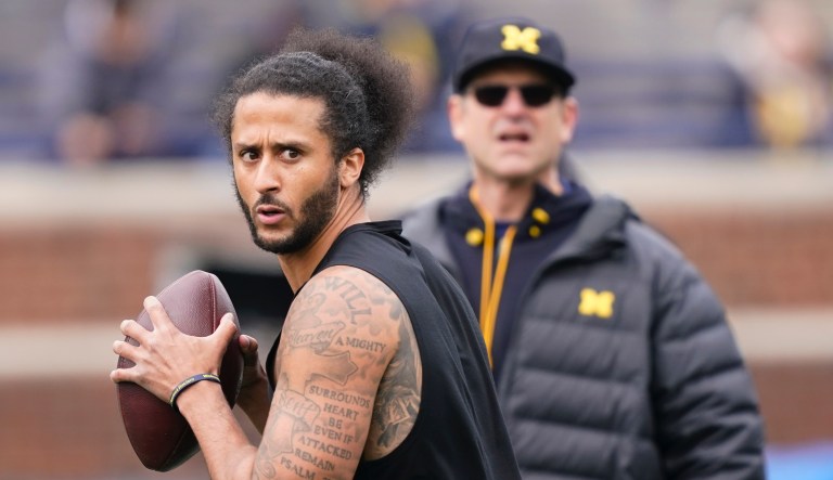Michigan head football coach Jim Harbaugh watches as former NFL quarterback Colin Kaepernick throws during halftime of an NCAA college football intra-squad spring game, Saturday, April 2, 2022, in Ann Arbor, Mich.