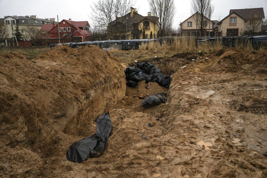 Bodies lie in a mass grave in Bucha, on the outskirts of Kyiv, Ukraine, on Sunday. Ukrainian troops are finding brutalized bodies and widespread destruction in the suburbs of Kyiv, sparking new calls for a war crimes investigation and sanctions against Russia.