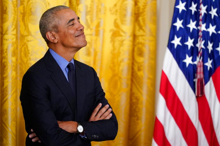 Former President Barack Obama looks on as President Joe Biden speaks duding an event about the Affordable Care Act, in the East Room of the White House in Washington, Tuesday, April 5, 2022.