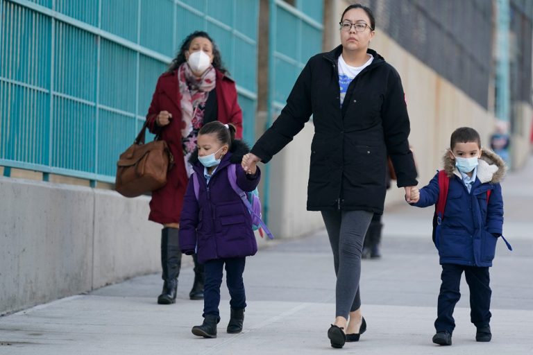 Children and their caregivers arrive for school in New York, Monday, March 7, 2022. The CDC has updated its travel assessment map and determined that no country is at its Level 4 designation in which the agency advises against travel.  