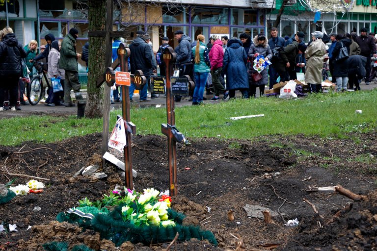 Civilian evacuation from Mariupol disrupted by Russian military Local residents gather at a makeshift street market next to two fresh graves in the foreground in an area controlled by Russian-backed separatist forces in Mariupol, Ukraine, on Friday.