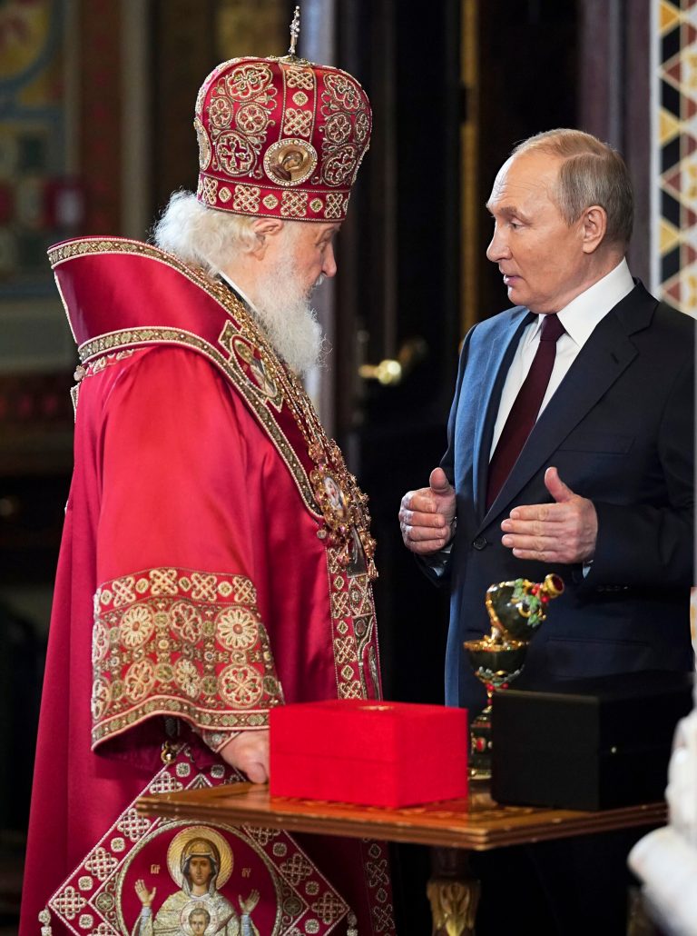 Patriarch Kirill listens as Russian President Vladimir Putin speaks.