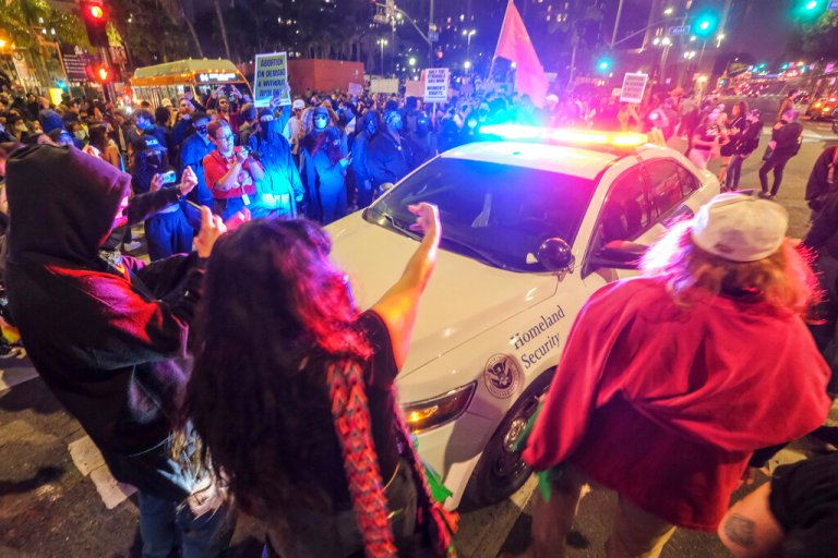 Demonstrators surround a police officer in his vehicle near Pershing Square after protesting outside the U.S. Courthouse in response to leaked draft of the Supreme Court's opinion to overturn Roe v. Wade in Los Angeles, Tuesday, May 3, 2022. 