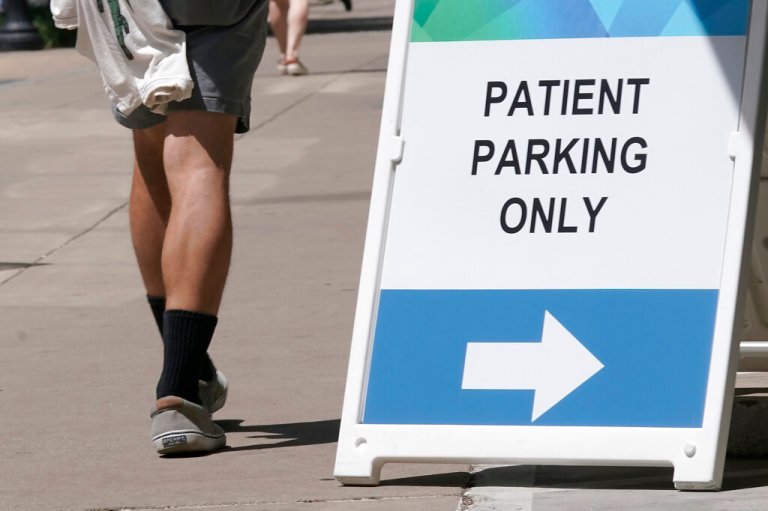 A sign directing where patients can park is displayed outside a medical facility in Sacramento, Calif., Wednesday, April 27, 2022. 