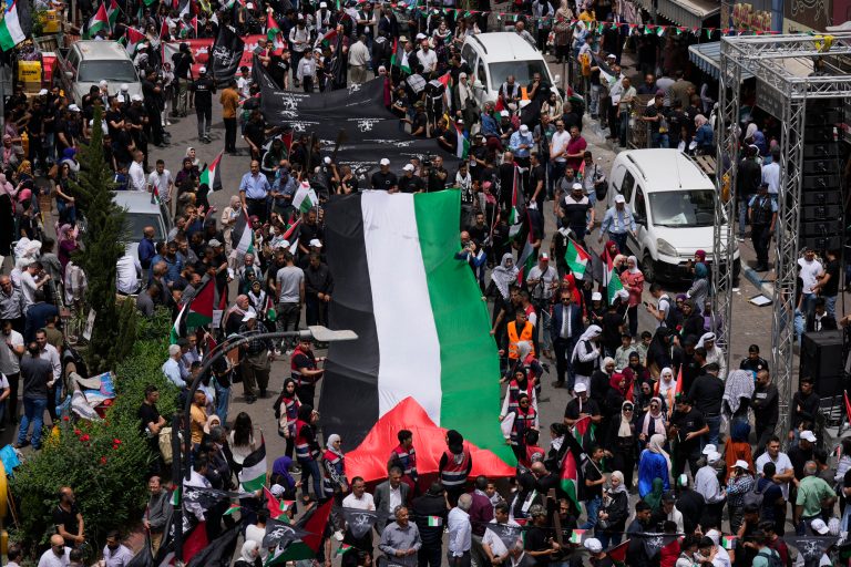 Palestinians carry a large national flag during a rally marking the 74h anniversary of what the Palestinians call the 