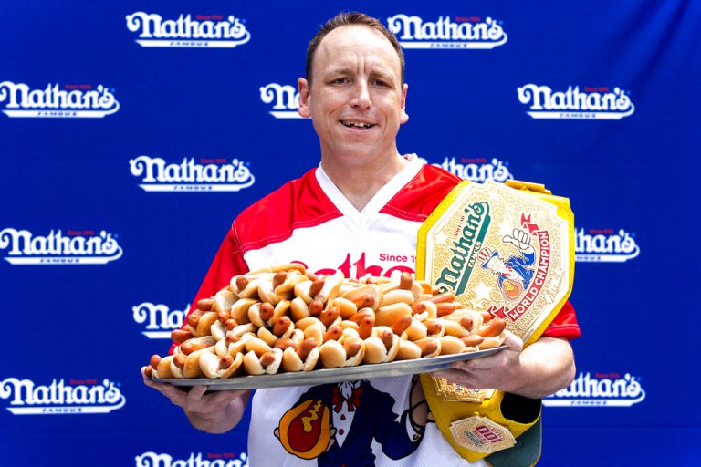 Competitive eater Joey Chestnut poses for photos with 76 hot dogs at a weigh-in before the Nathan's Famous July Fourth hot dog eating contest, Friday, July 1, 2022, in New York. Chestnut is seeking to set a new world record this year.