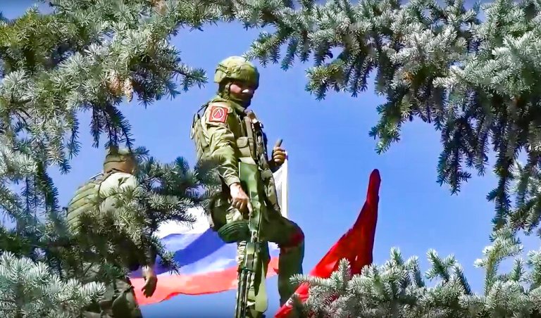 In this handout photo released by Russian Defense Ministry Press Service on Sunday, July 3, 2022, Russian soldiers set a Russian national flag and a replica of the Victory banner atop of the administration after capturing the eastern village of Bilohorivka which is now a territory under the Government of the Luhansk People's Republic control, eastern Ukraine.